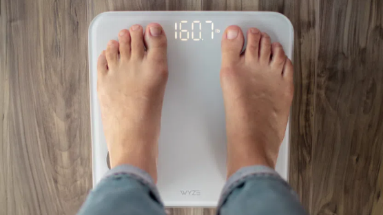 Person standing on white wyze scale s to see their weight