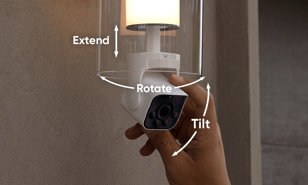 Hand adjusting camera head of the Wyze Bulb Cam