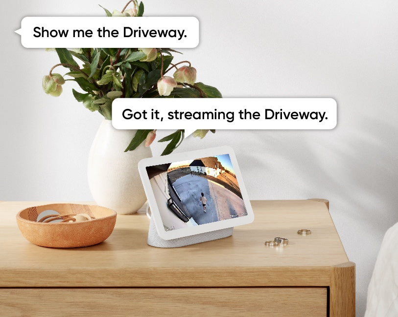 A tablet computer displaying a live video feed from a security camera mounted outside. The cam is showing a person standing in driveway..