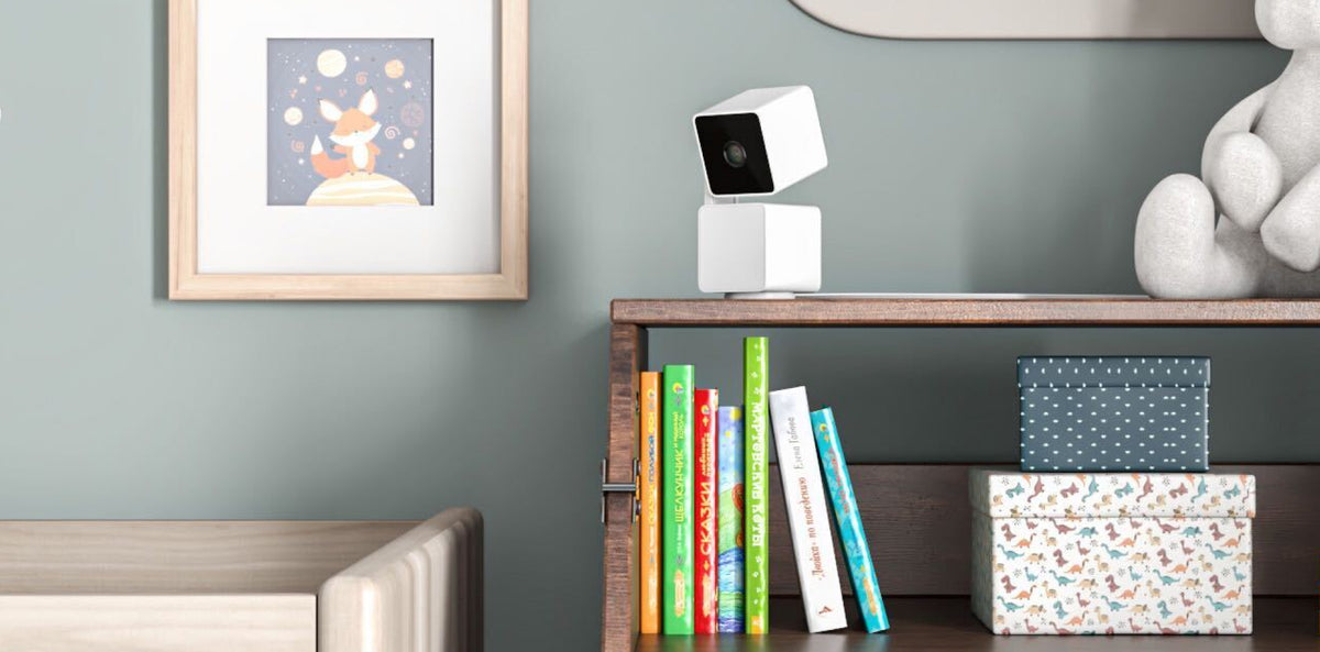 A white camera on a shelf.
