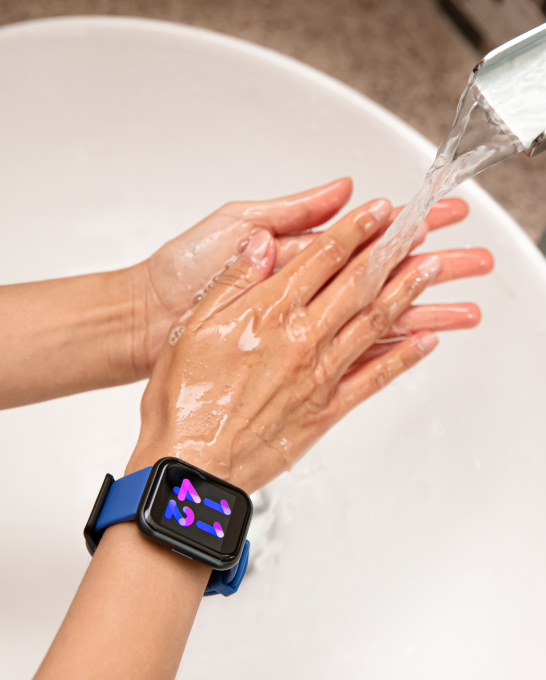 Person washing their hands in a sink with a wyze watch 44 on their wrist
