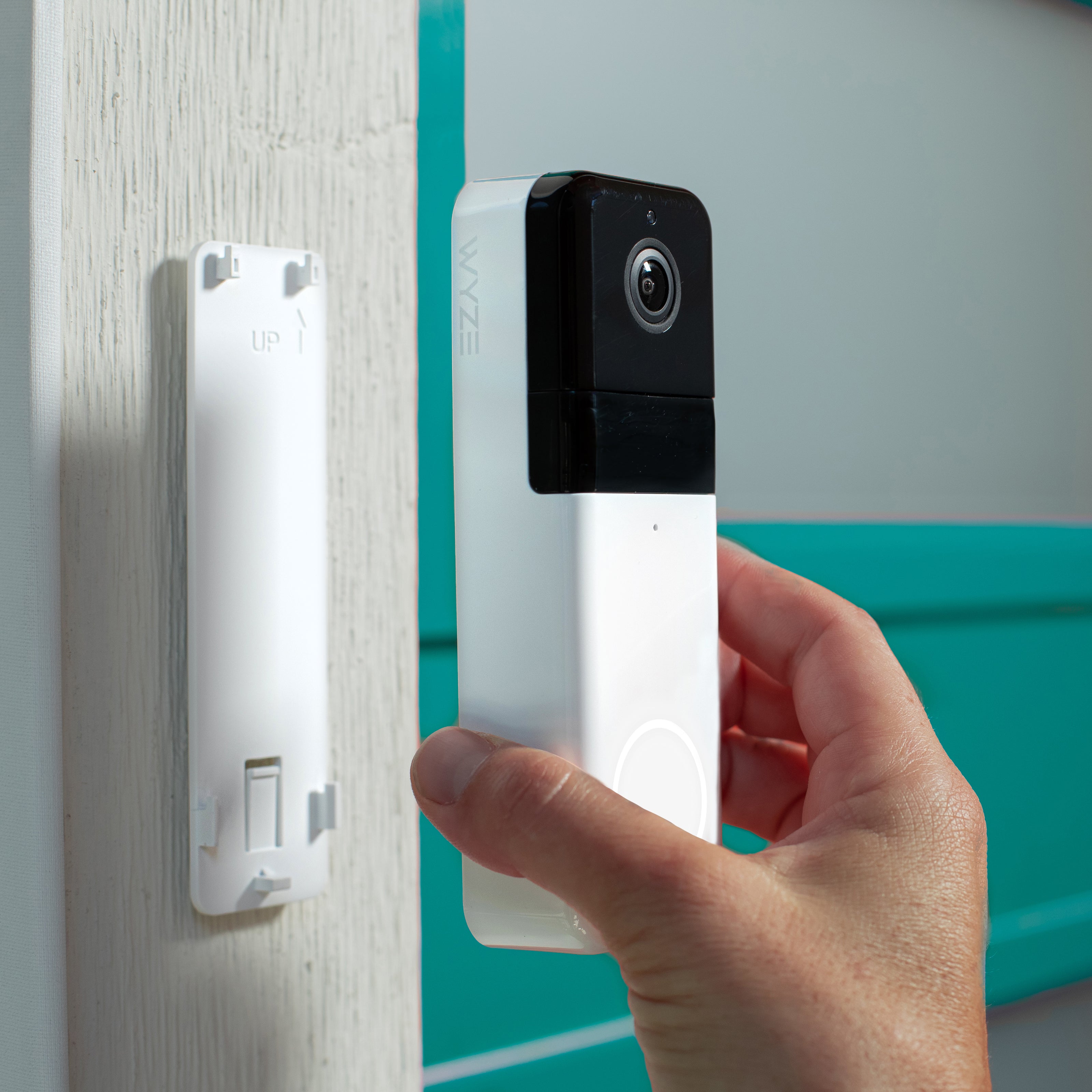 A homeowner easily installing a Wyze Video Doorbell, demonstrating the simple DIY process.