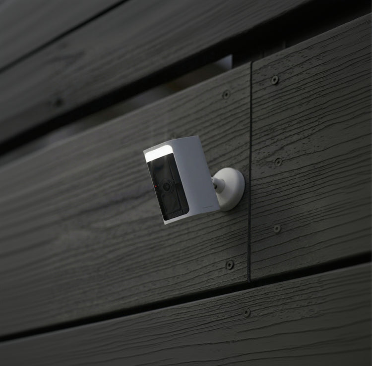 Security camera mounted on a wooden wall