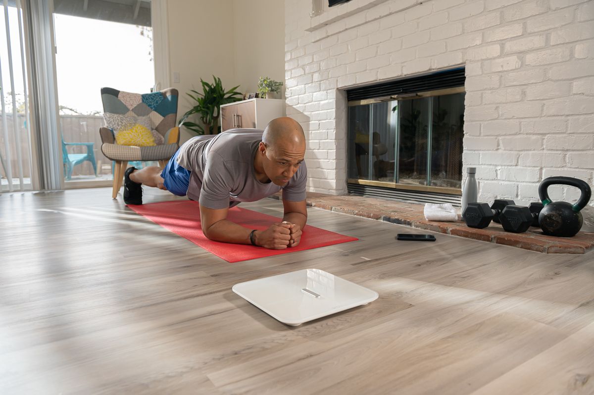 Man exercising in background, White scale x on floor infront of him
