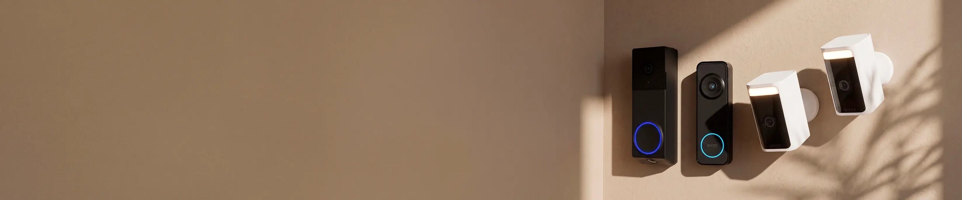 Four smart doorbells of different models on a beige wall.