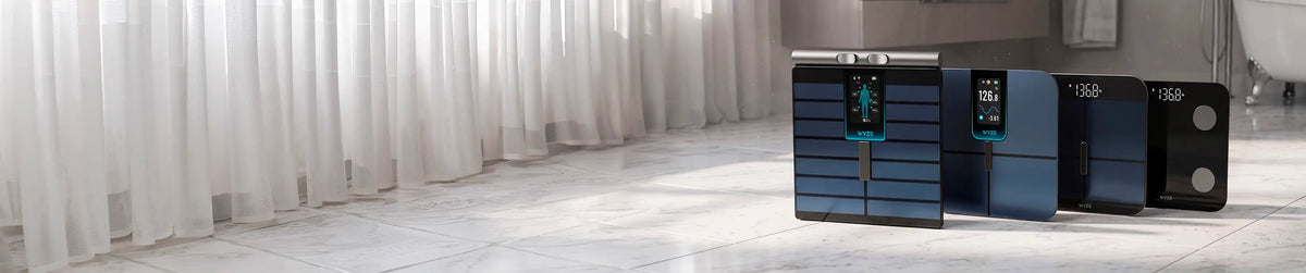 Three electronic devices on a white surface with a blurred background