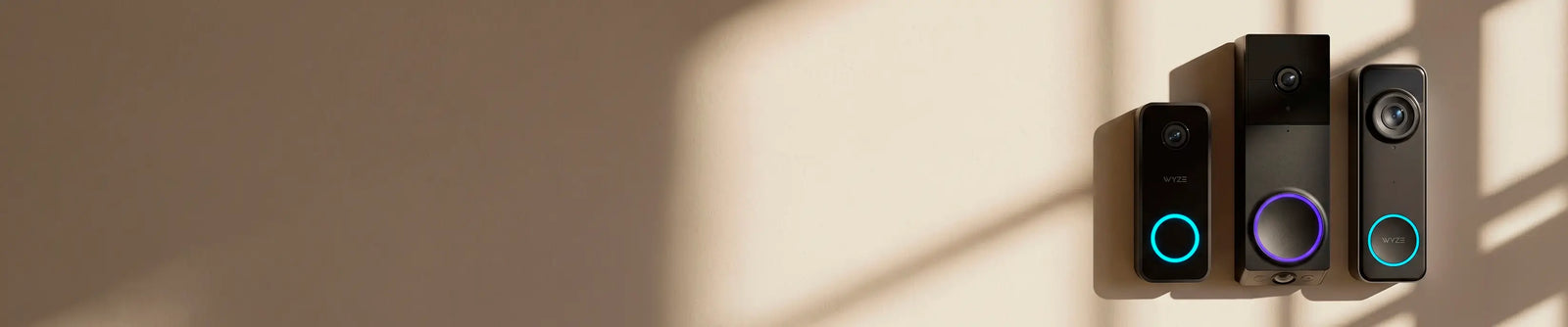 Four black electronic devices with colorful lights on a beige wall