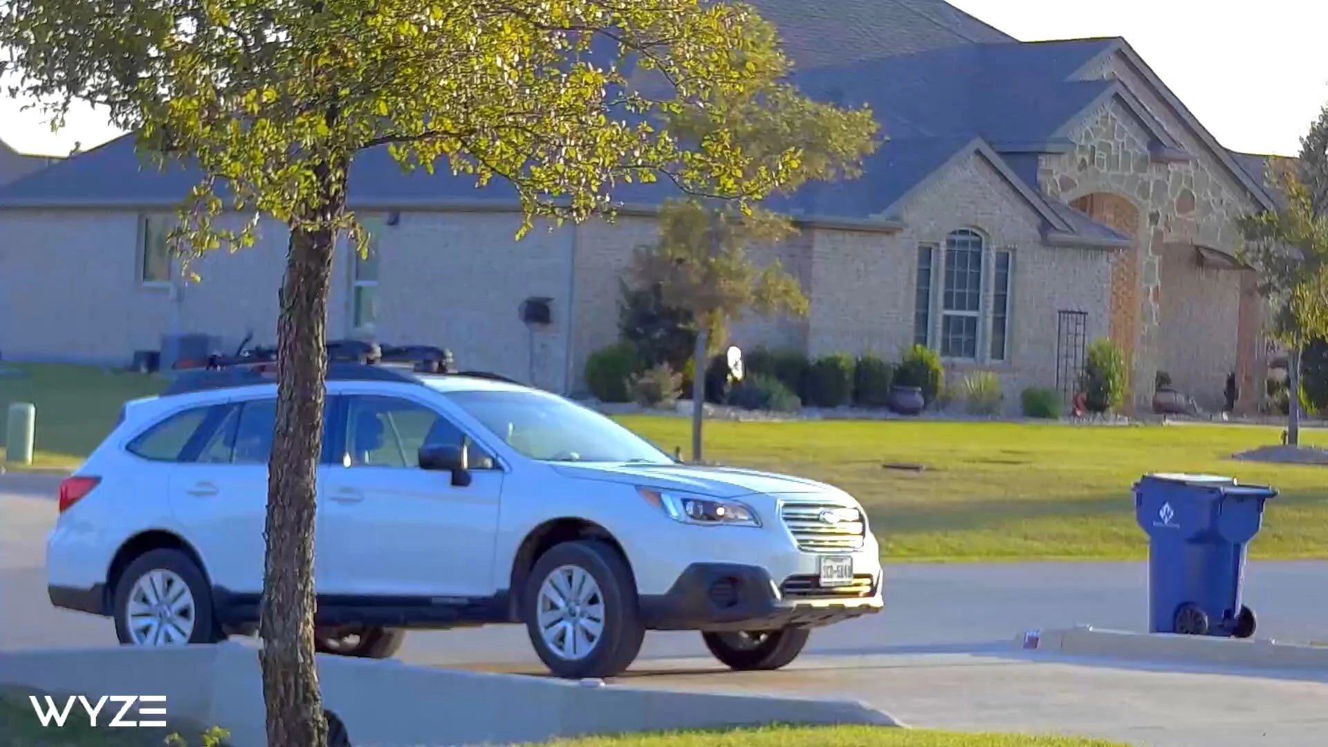 Telephoto view of the front of a house with a close up of a car.