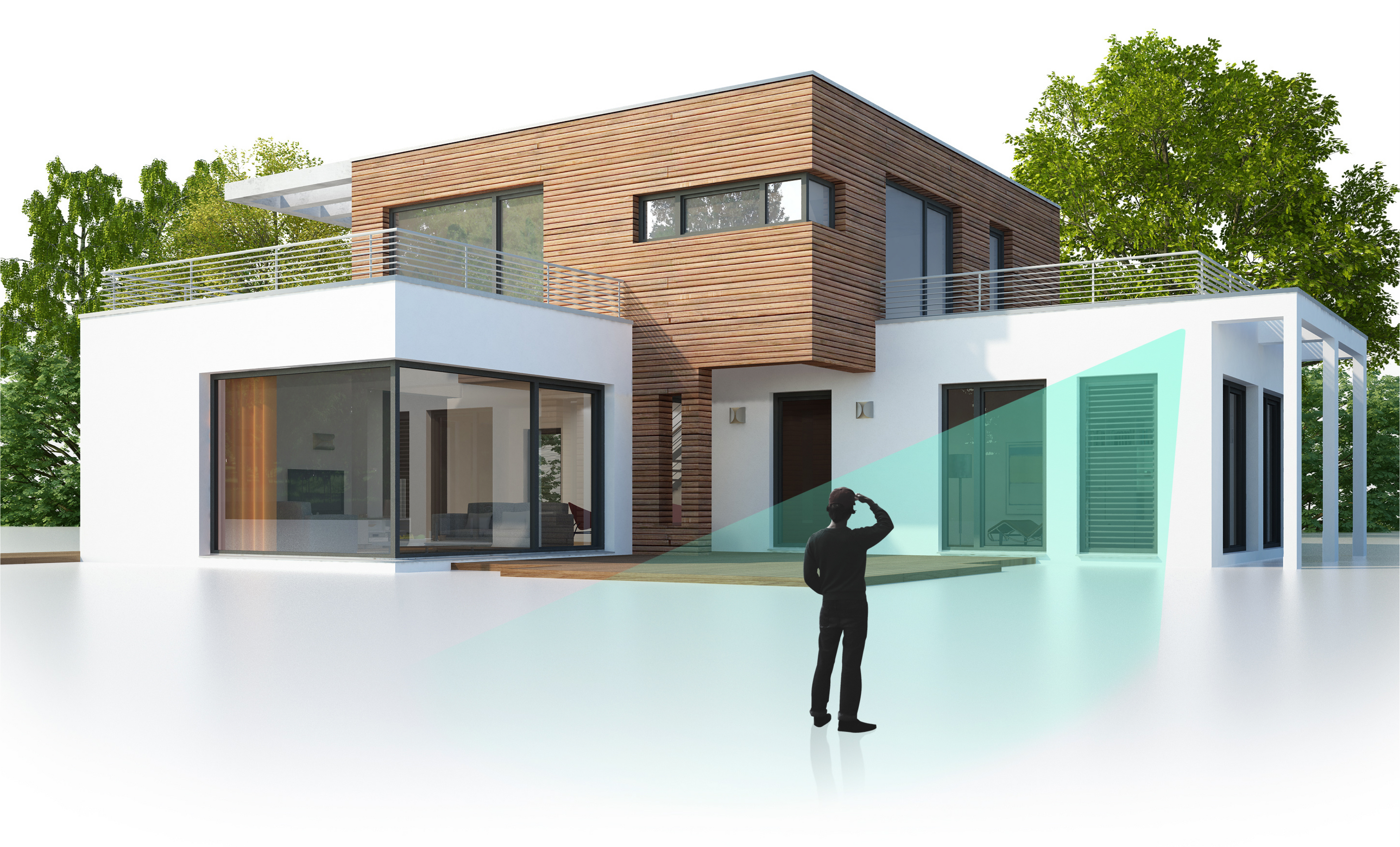 A man is standing in front of a house, looking at his phone.