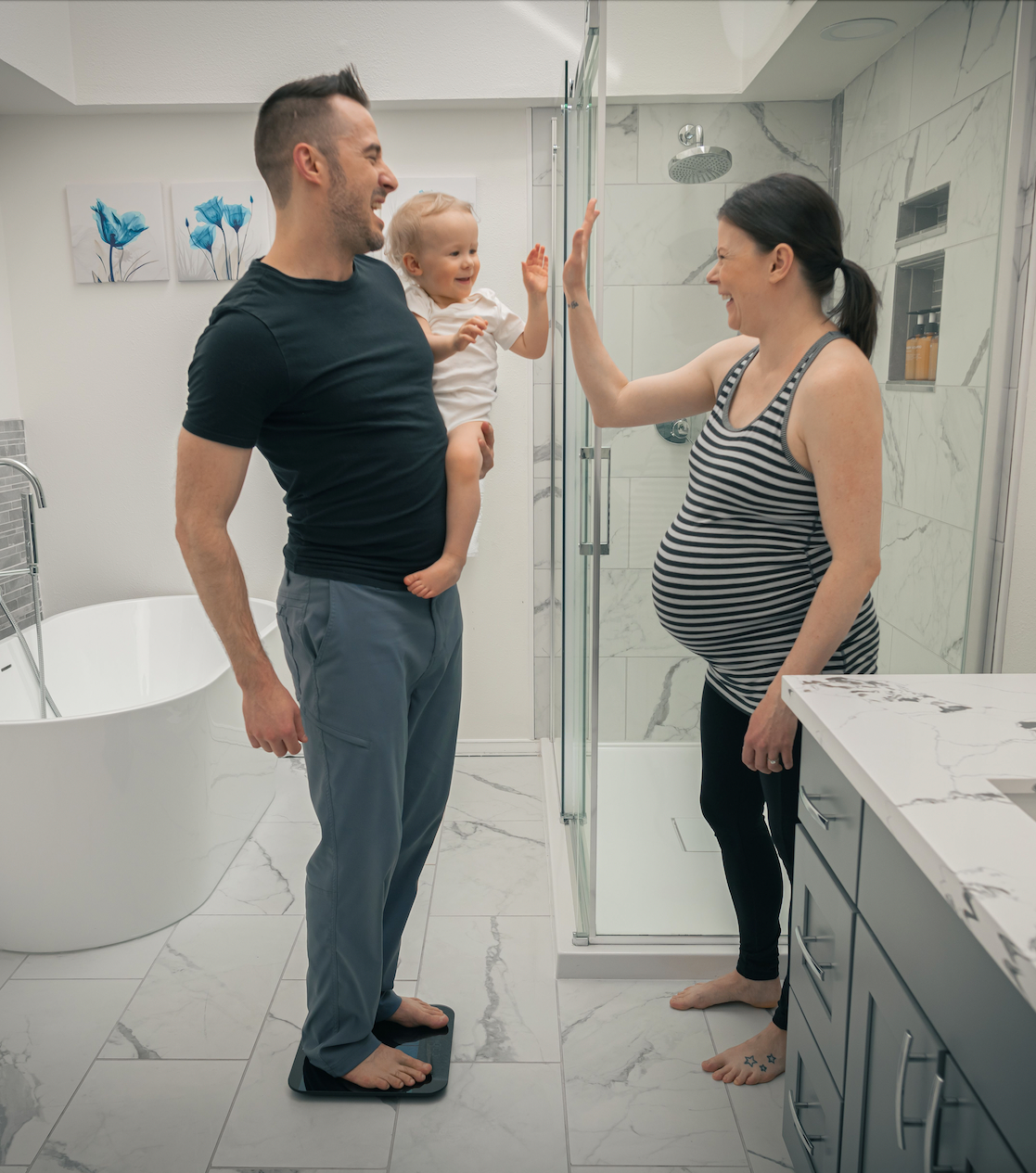 Man standing on scale while holding a child