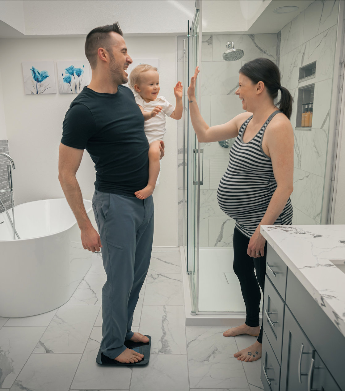 A man holding a baby in a bathroom.