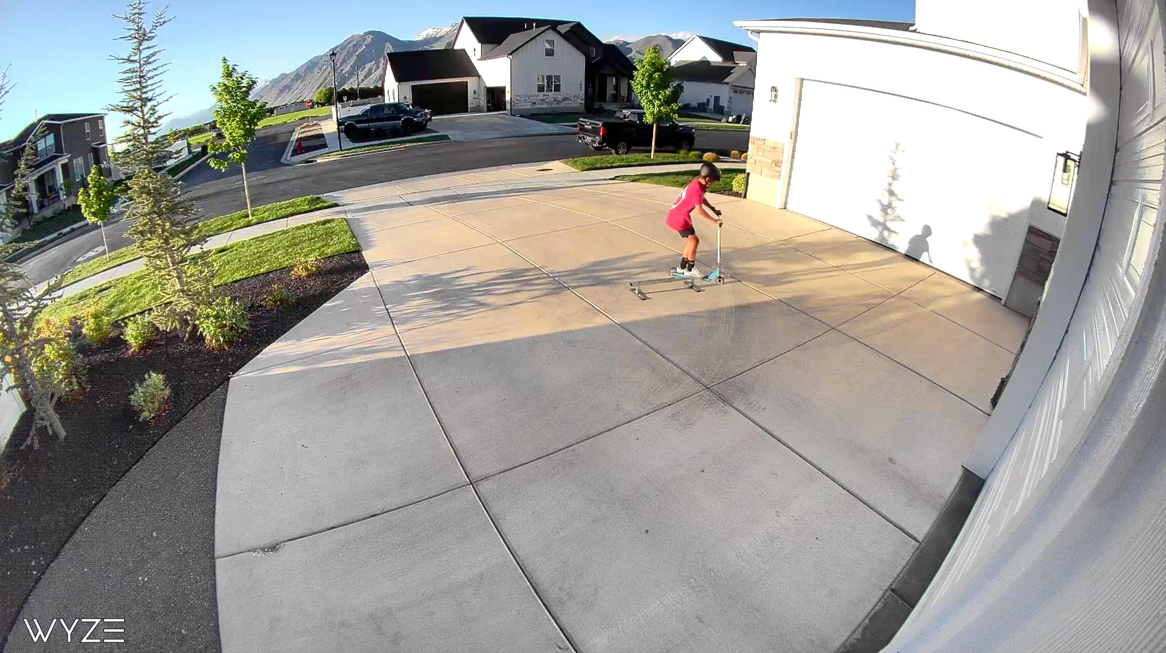 A person riding a skateboard in a driveway.