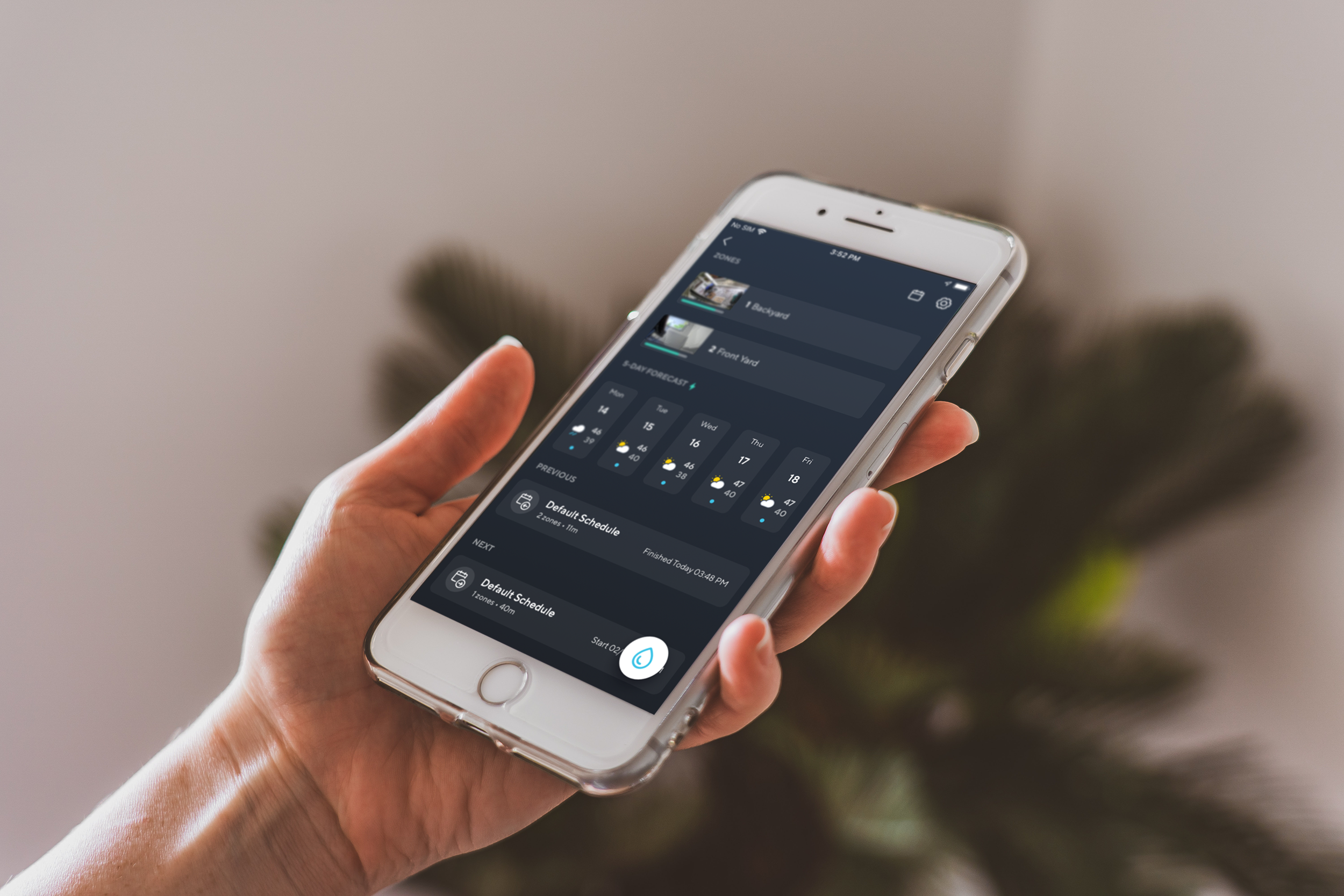 A person holding a smartphone with the Wyze app open to sprinkler settings.