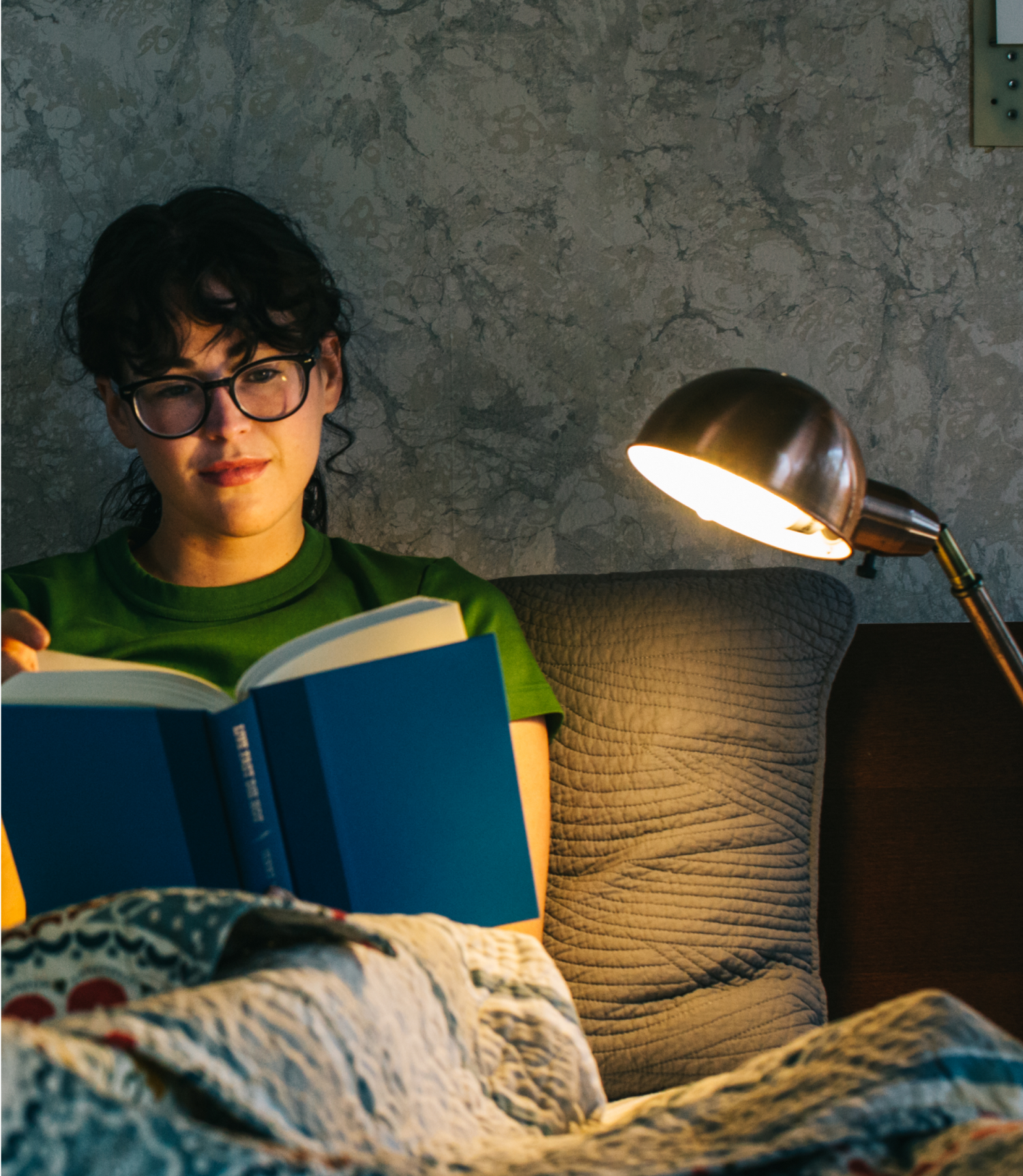 Person reading a book in bed