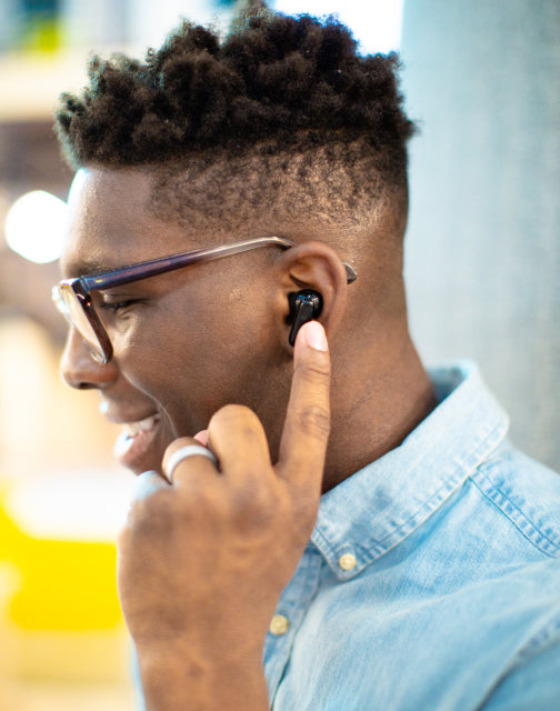 Person touching Wyze buds pro in their ear