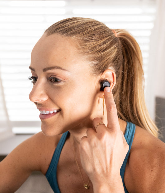 Person wearing wyze buds pro with their finger against the side to engage virtual assistant