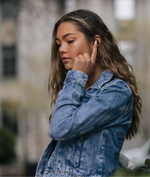 Person touching Wyze buds in their ear with their finger to use Alexa built in.