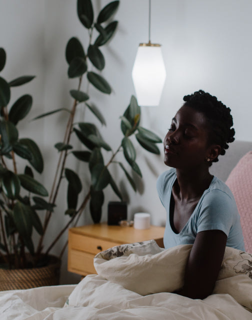 Person waking up in bed with light in background