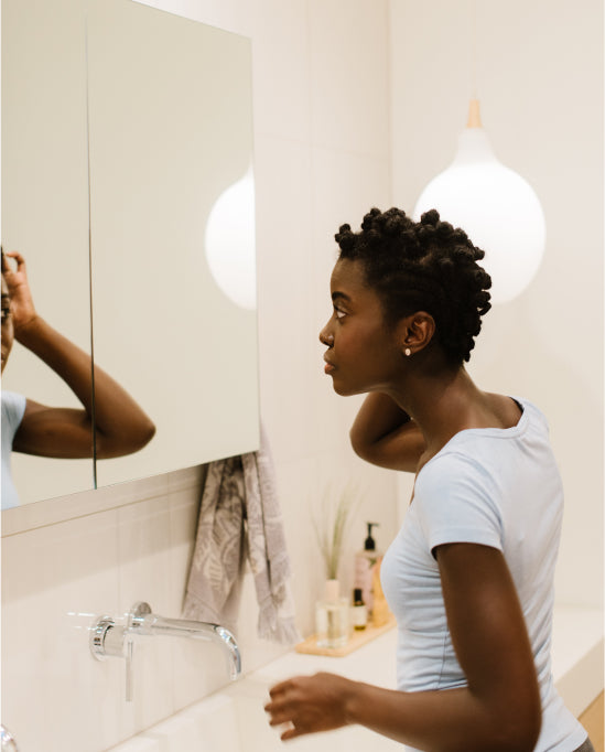 Person looking at themselves in the mirror with light in background