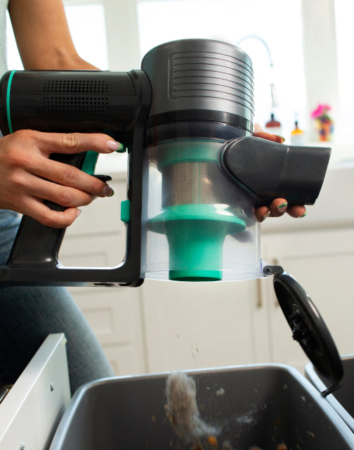 Person emptying the dust cup into a garbage can