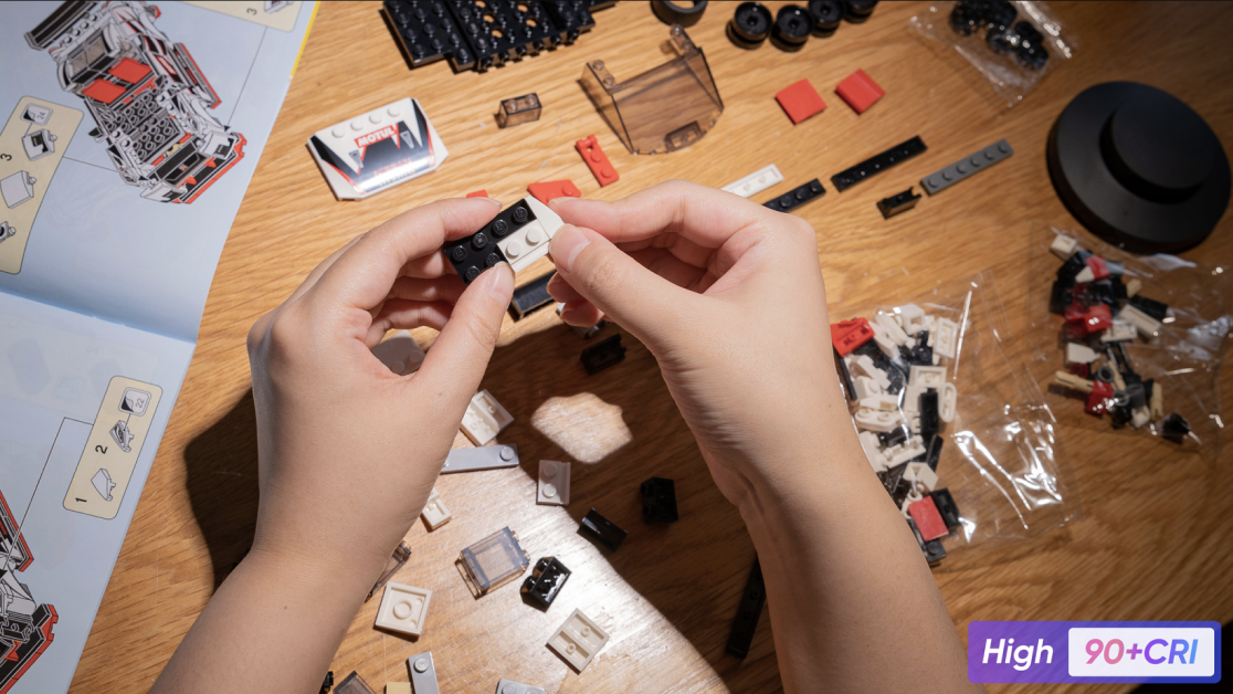 A person is building a floor lamp with legos.