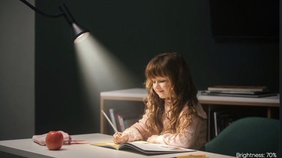Wyze Floor Lamp shining a light on a little girl writing in an activity book at her desk
