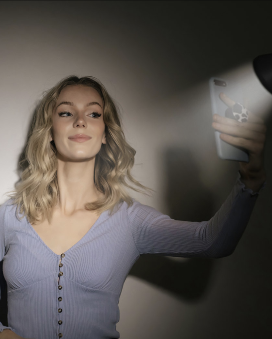 Person taking a selfie in floor lamp lighting