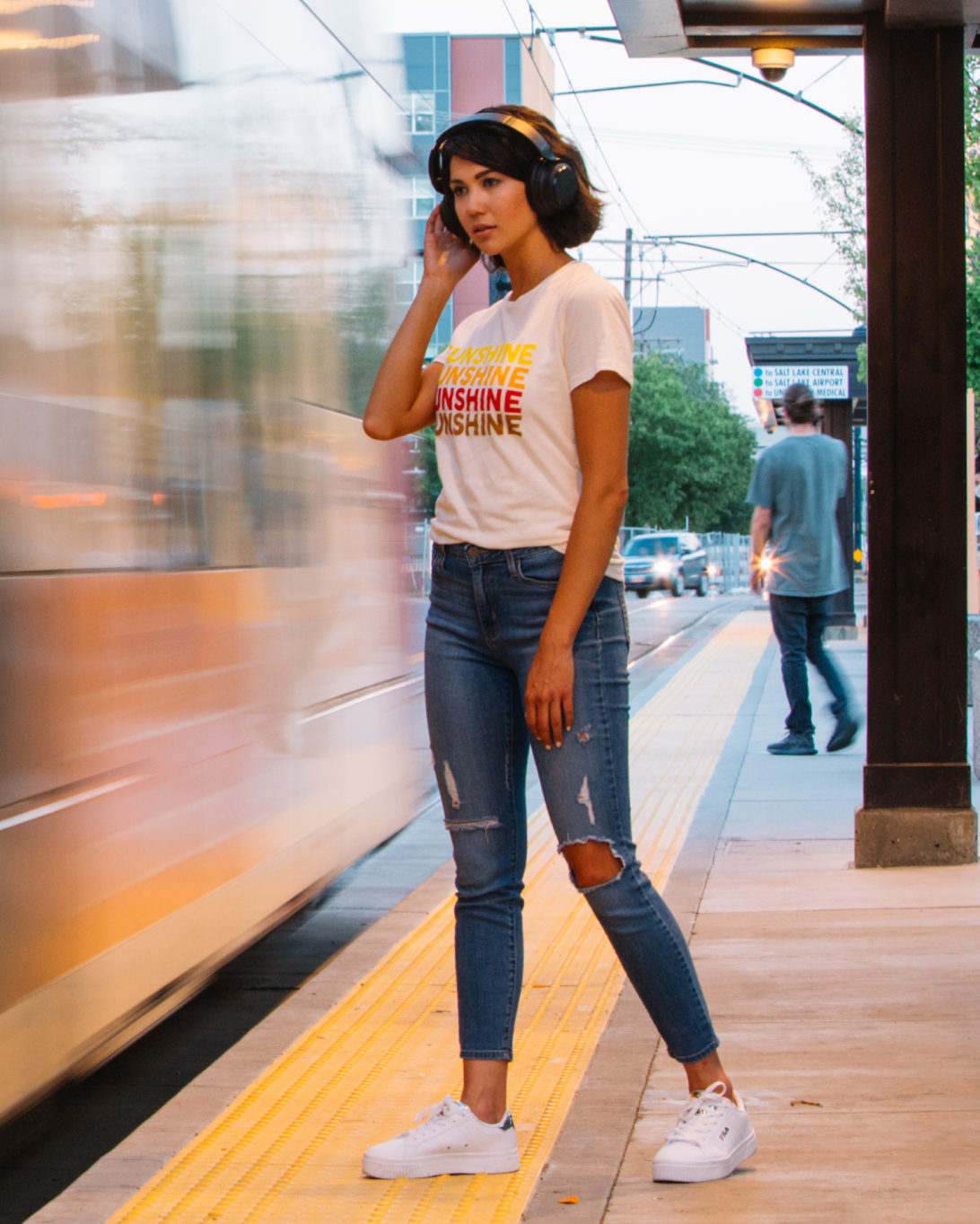 Person standing on train platform wearing wyze headphones