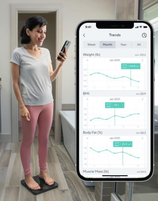 Person standing on wyze scale while checking their stats on the wyze app on their phone