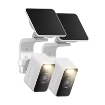 Two white Wyze Solar Cam with its spotlight illuminated and solar panel mounted above on a wall bracket.