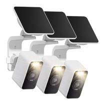 Three white Wyze Solar Cam with its spotlight illuminated and solar panel mounted above on a wall bracket.