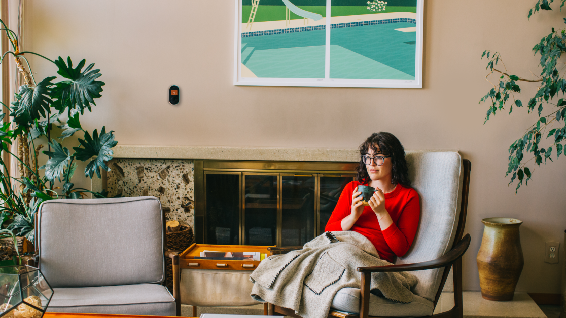 A woman sitting in a chair with a cup in her hand.