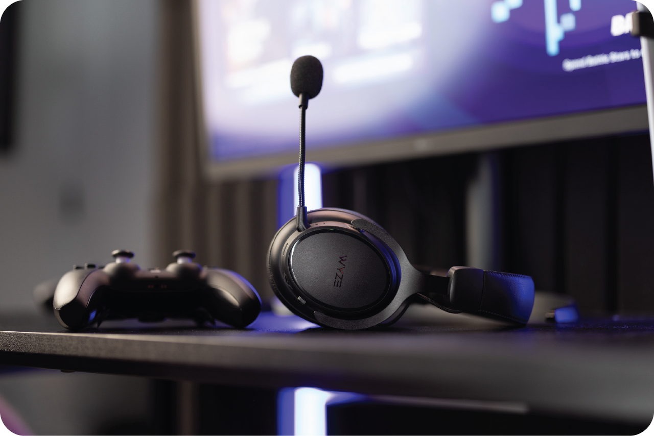 A black gaming headset with a microphone on a table next to a gaming controller.