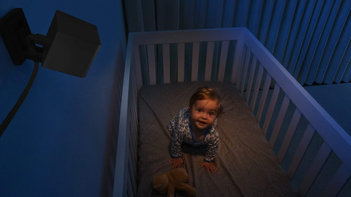 A baby in a crib with a stuffed animal.