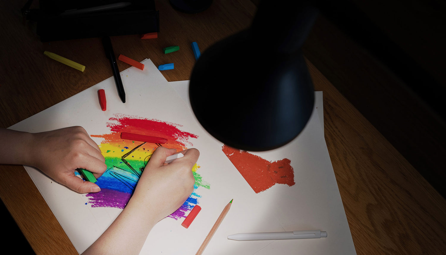 person coloring with floor lamp turned on