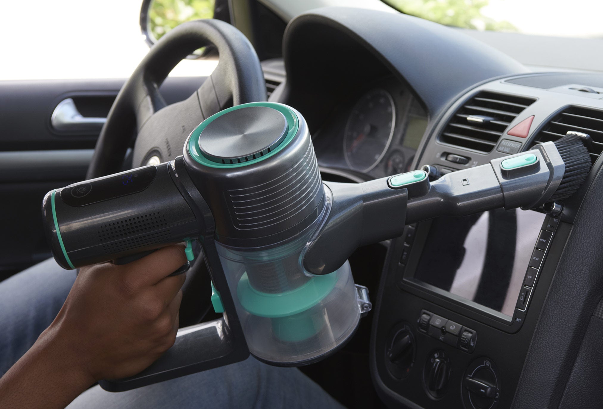 Person vacuuming their car with the cordless vacuum