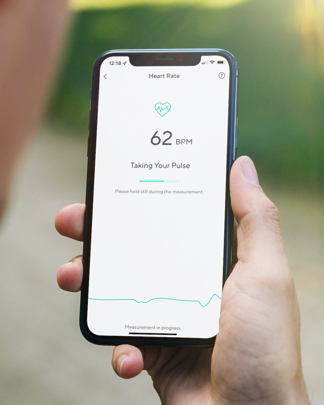Person holding phone with wyze app opened to heart rate page