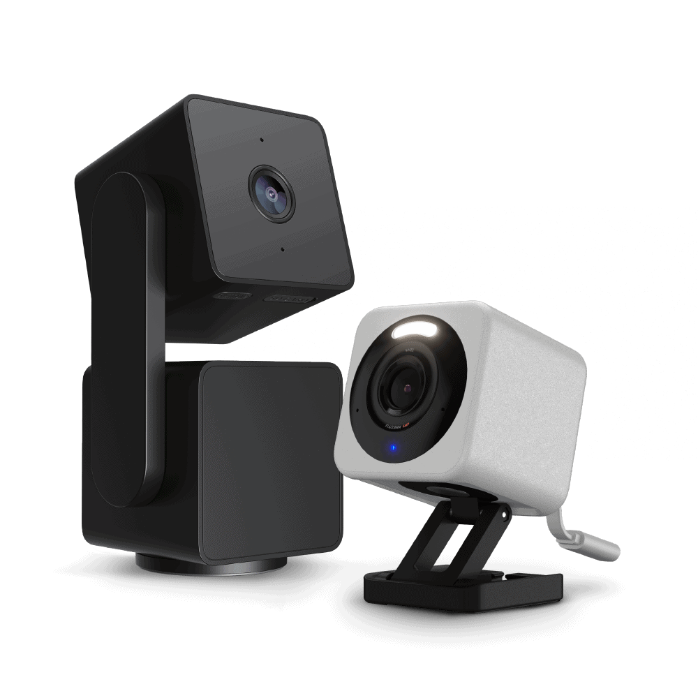 Two security cameras, one black and one white, on a transparent background