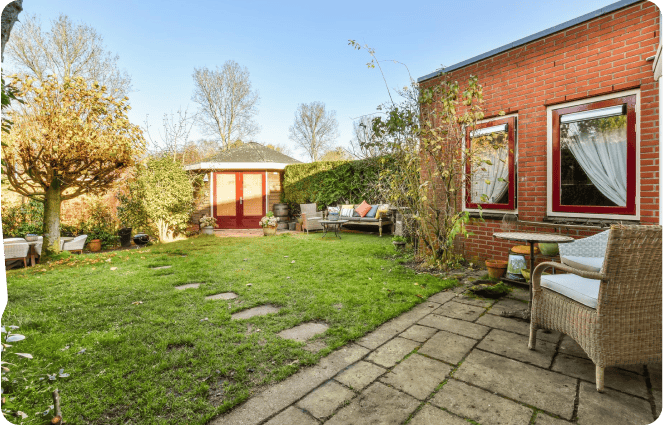 A backyard with a patio set and a brick wall.
