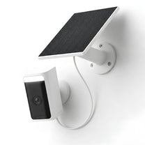 A white camera with a black lens on a wall.