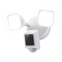 A white security camera with a green background.