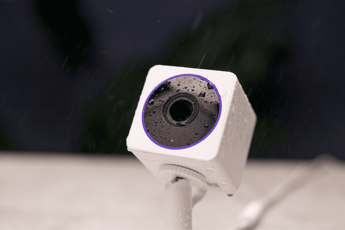A security camera with a purple ring around the lens.