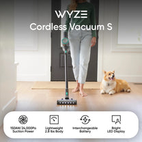A woman standing in a room with a cordless vacuum cleaner.