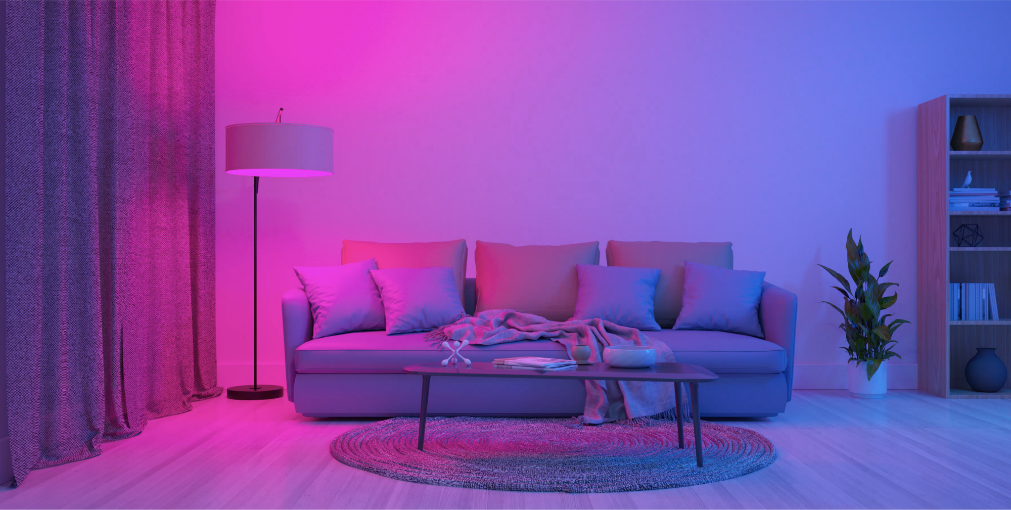 A purple and pink couch with a lamp on a table in front of it.