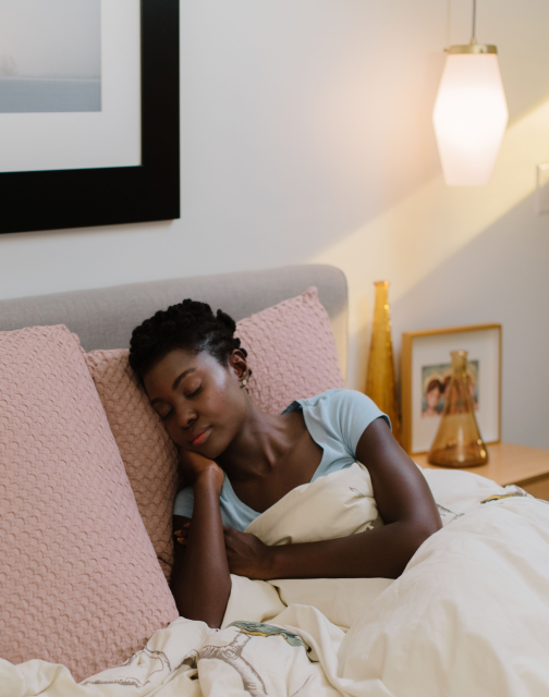 sleeping person with lights on in room