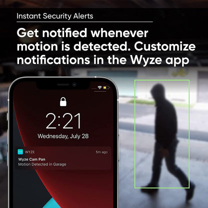 Text overlay "Instant Security Alerts." Smartphone with notification from Wyze app while a person is in the background.