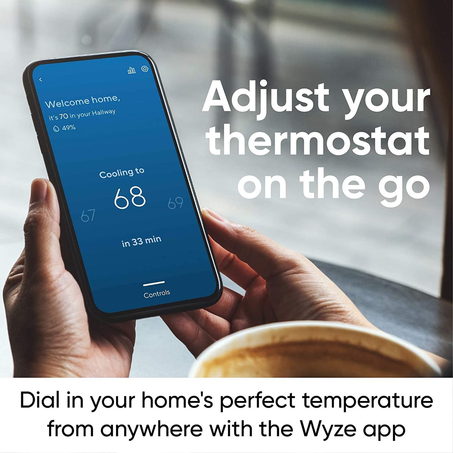 Hands holding a smartphone with the Wyze app open with the Thermostat dashboard open. White text overlay that says "Adjust your thermostat on the go."