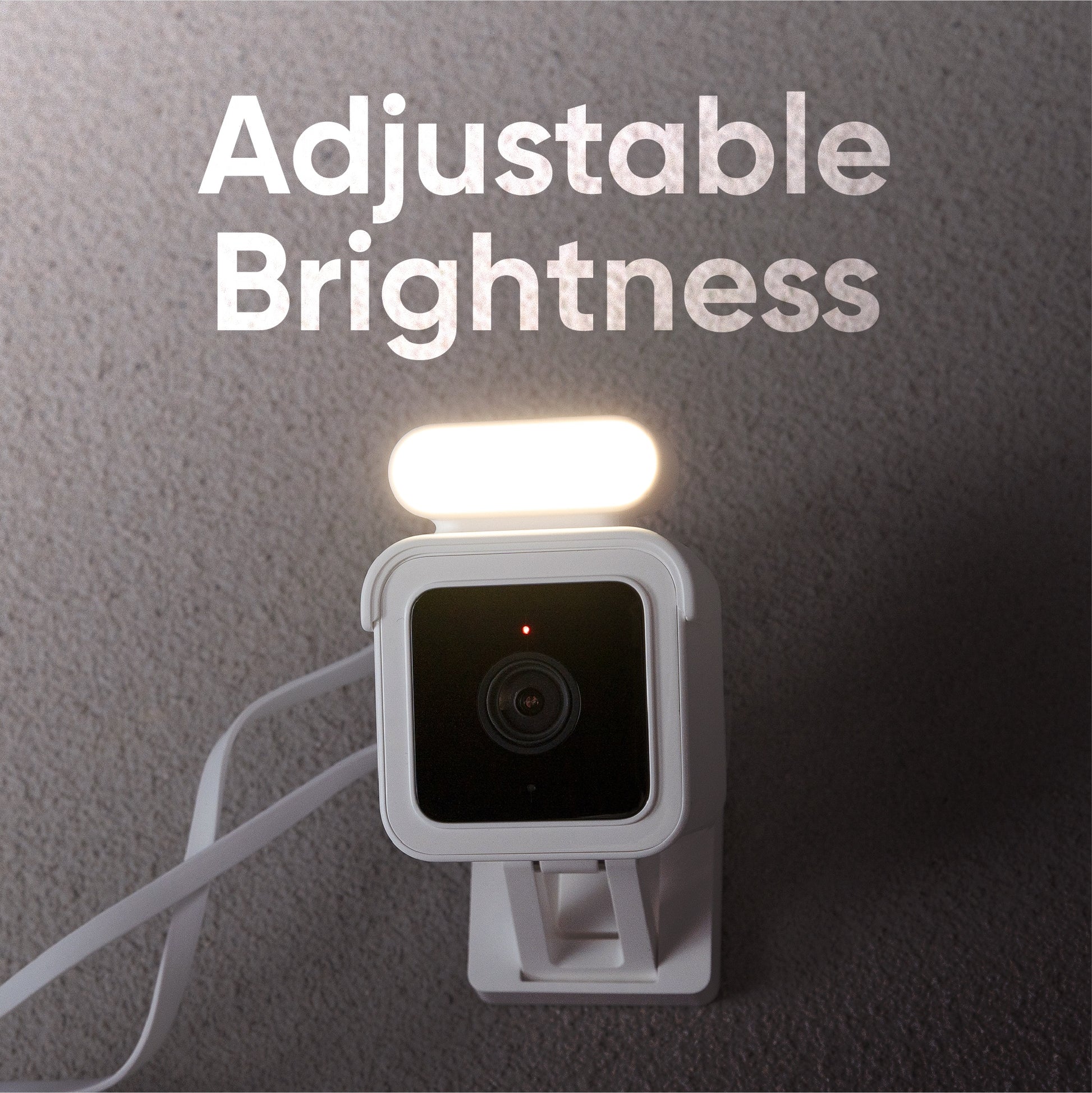 Wyze Cam v3 with Spotlight above, turned on. Text overlay "Adjustable brightness". 