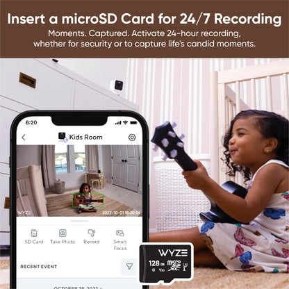 Wyze app on smartphone showing kid playing the guitar. Text overlay "Insert a MicroSD Card for 24/7 Recording."