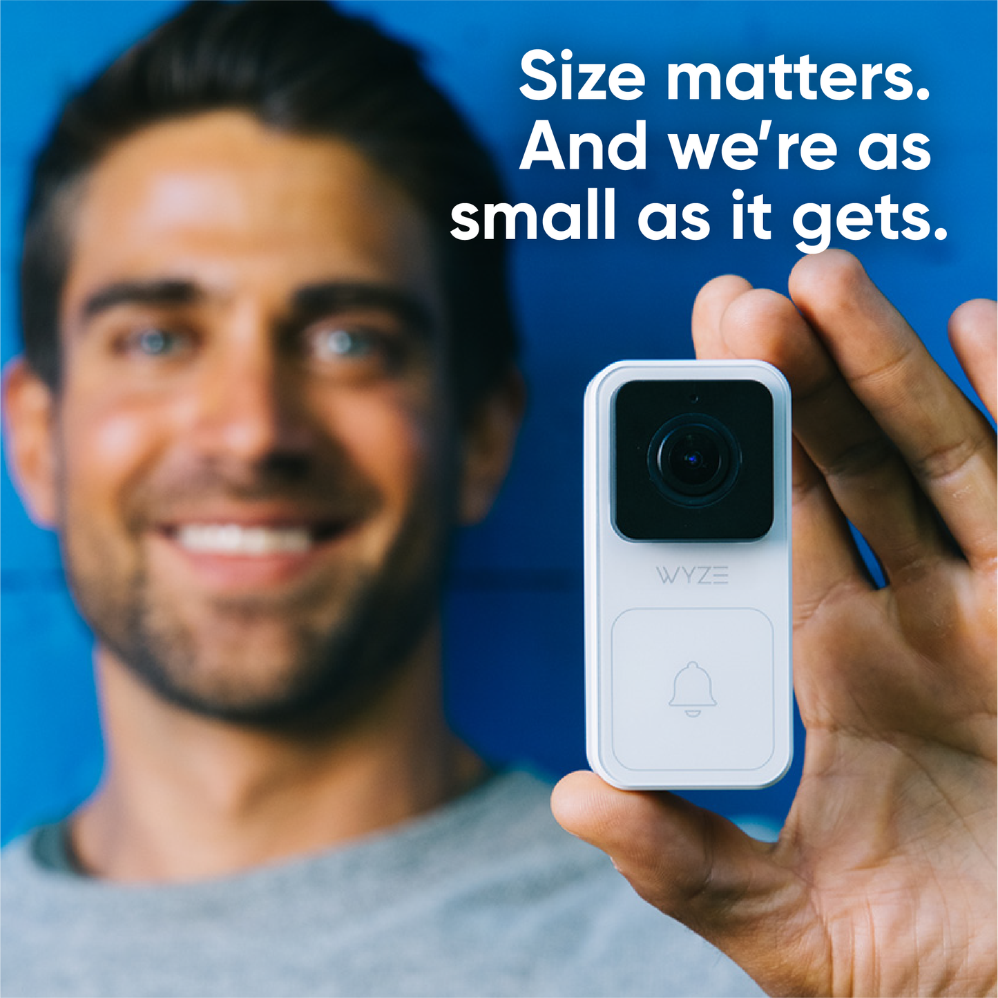 Guy holding Wyze video doorbell in hand. Text overlay "As small as it gets."